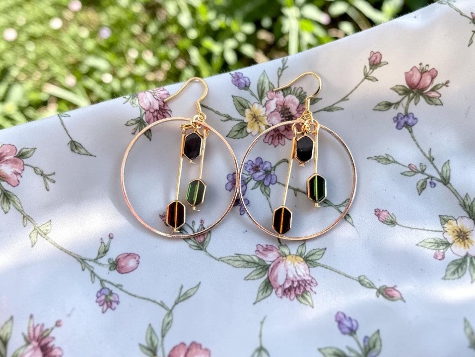 UniquelyYou gold-tone hoop earrings with dangling geometric beads in black, green, and amber. Bohemian style.
