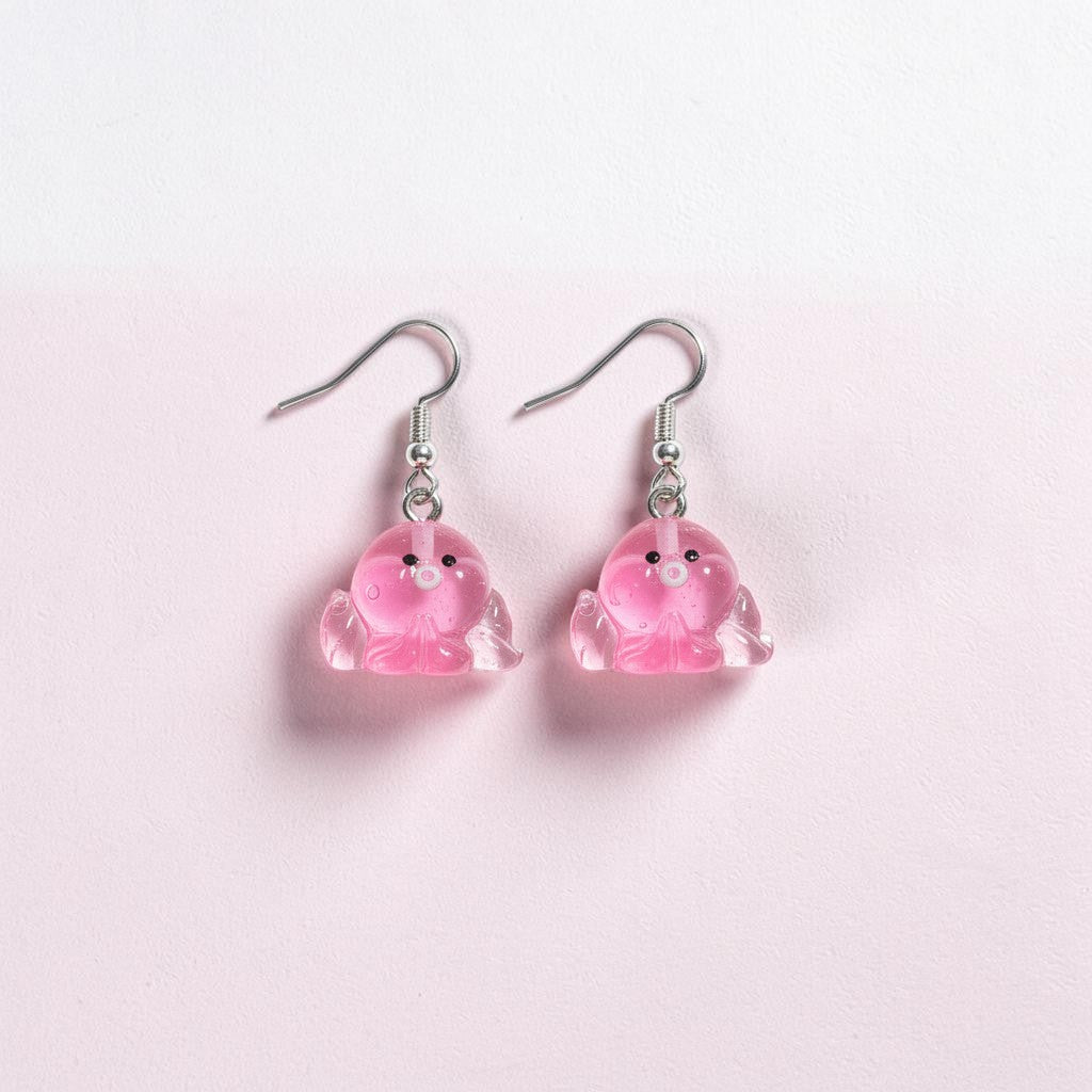 UniquelyYou pink translucent resin octopus earrings with black eyes and white center detail.